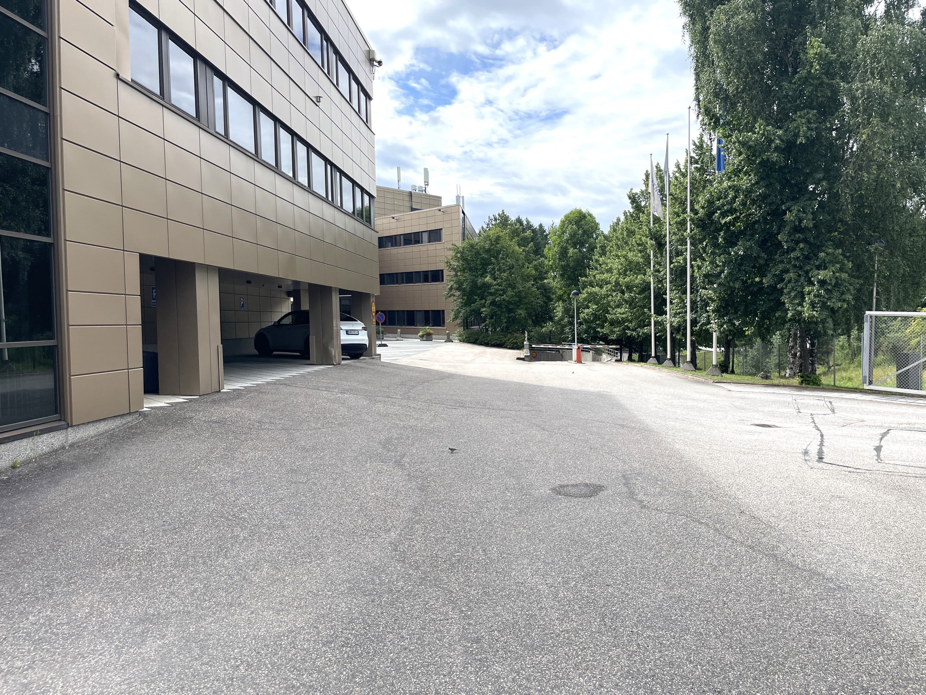Moderni toimistorakennus ja asfaltoitu piha-alue.