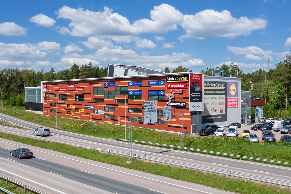 MotorCenter-liikerakennus maantien varrella aurinkoisena päivänä.