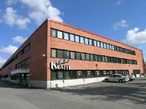 Kolmikerroksinen punatiilinen rakennus, jonka alakerrassa on lounasravintola Klaffi.