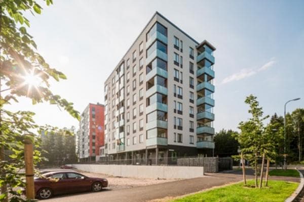 Moderni asuinkerrostalo aurinkoisessa kaupunkiympäristössä.