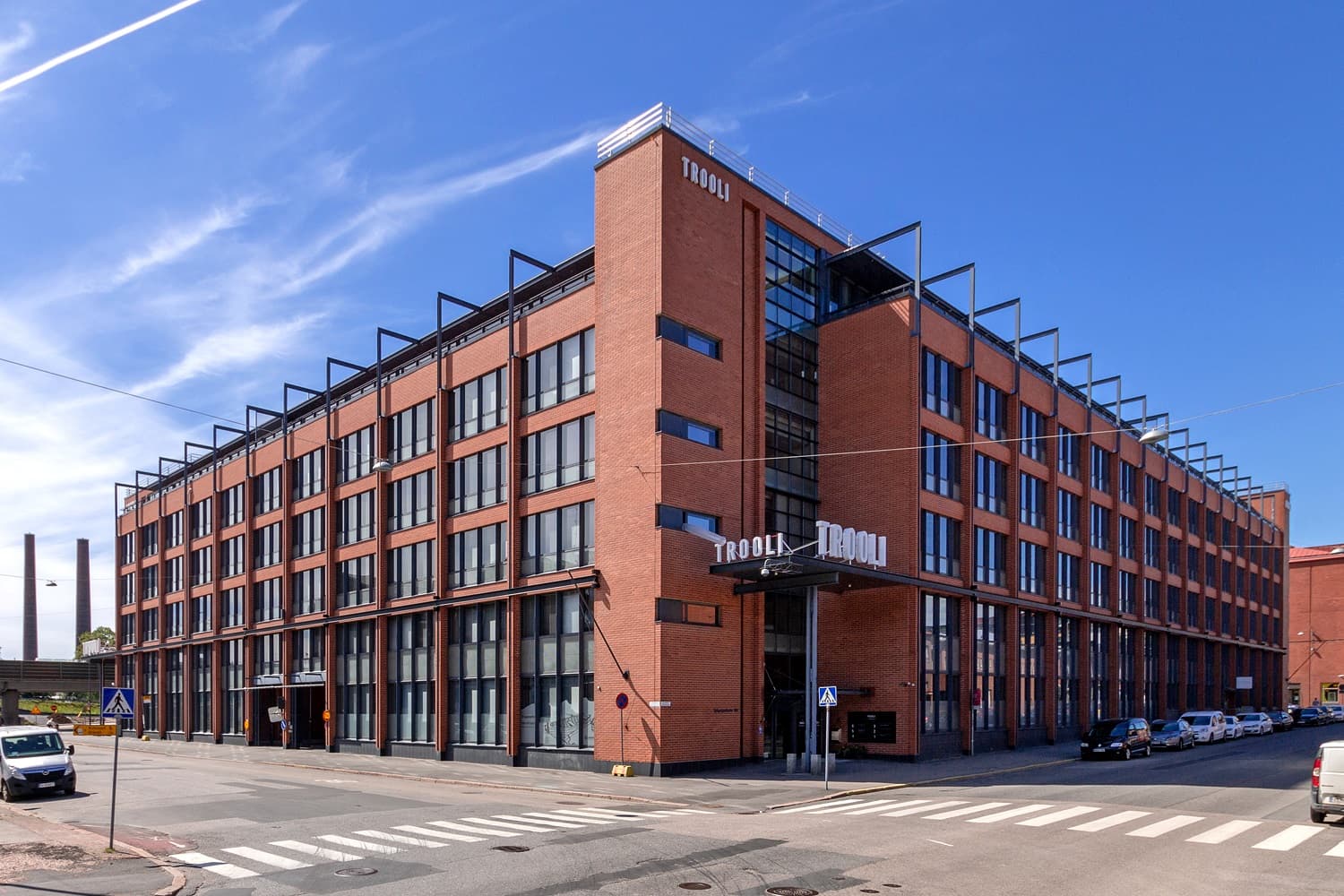 Punatiilinen Trooli-rakennus kadun kulmauksessa kirkkaana päivänä.
