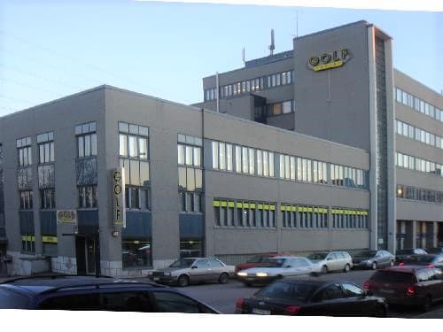 Monikerroksinen rakennus ja autoja kadulla.