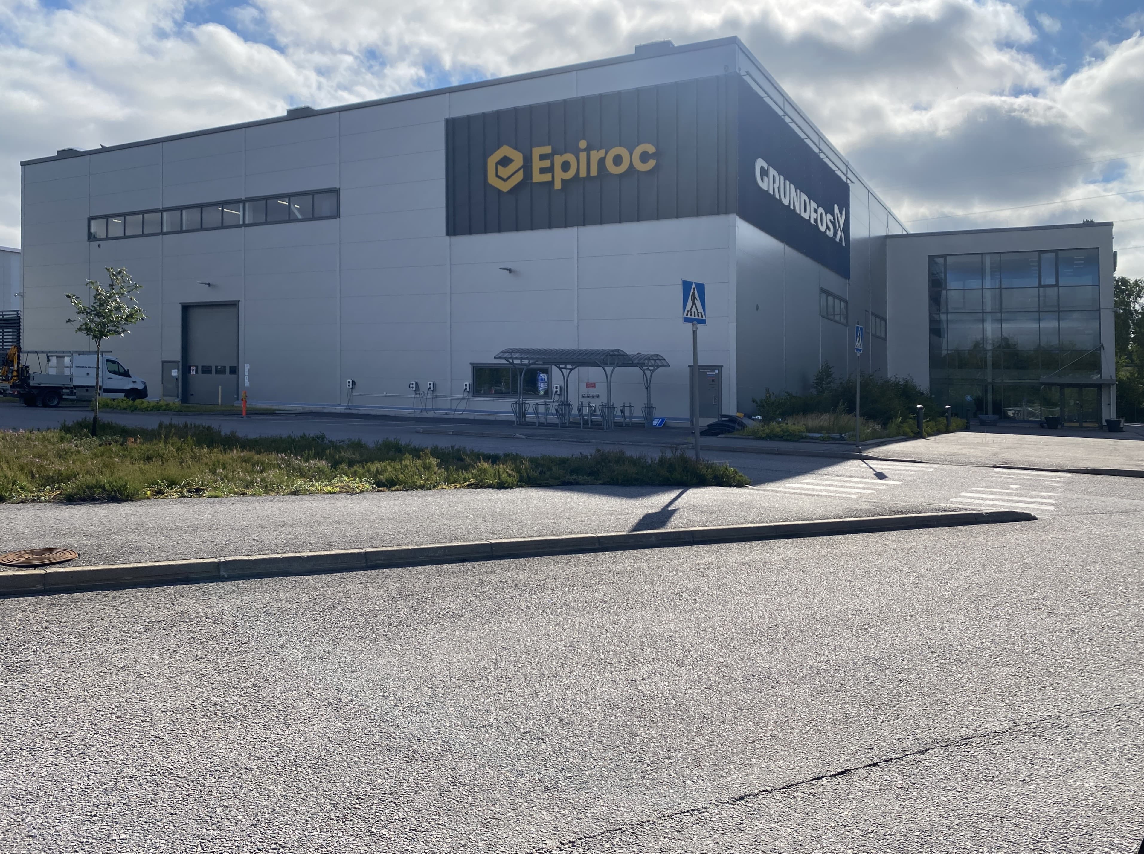 Harmaa teollisuusrakennus, jonka julkisivussa on Epiroc- ja Grundfos-logot.