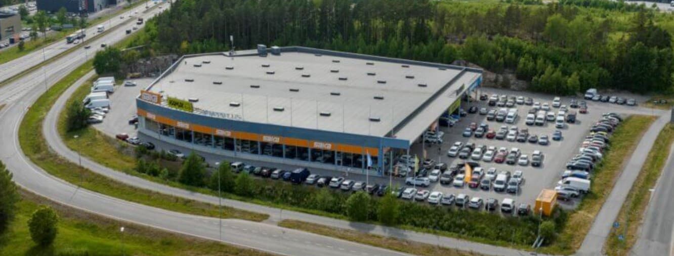 Ilmakuva autoliikkeestä ja sen laajasta pysäköintialueesta.
