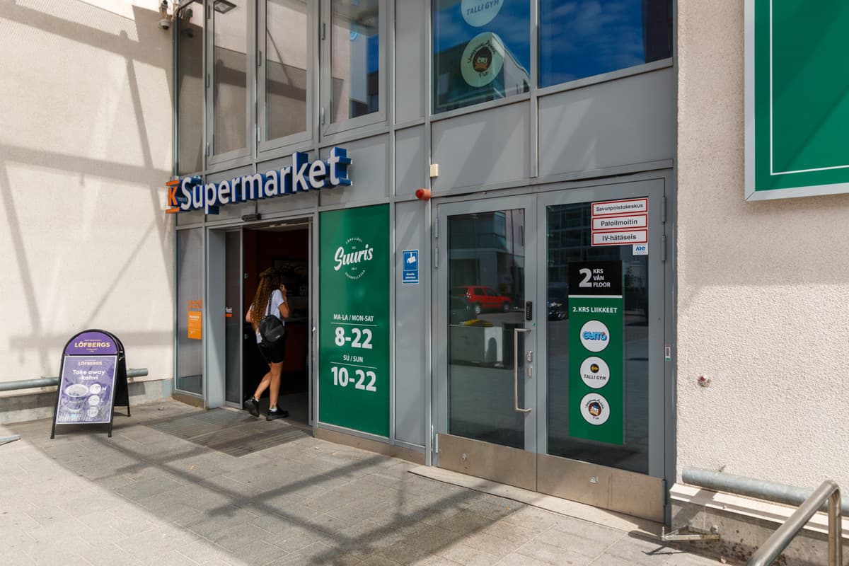 K-Supermarketin sisäänkäynti ja liikkeen aukioloajat.